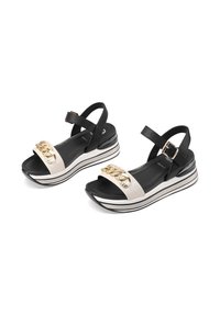 Sandali platform bicolore, neri e bianchi, con un design elegante, caratterizzati da un accento in catena dorata sulla fascia e una soletta nera testurizzata.