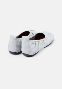 Bailarinas de cuero azul claro con acabado elástico y suelas de goma negra. Textura suave con punta redondeada y un diseño minimalista.