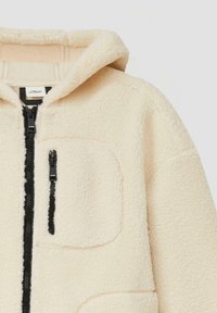 Cremfarbener Fleece-Jacke mit Reißverschluss vorne, verstellbarer Kapuze und schwarzem Reißverschluss. Verfügt über eine Brusttasche und eine weiche Textur.