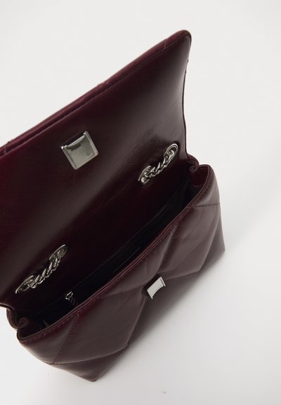 Sac à main en cuir bordeaux avec un design matelassé, des accents en métal argenté, une fermeture à pression carrée et une seule chaîne à l'intérieur.