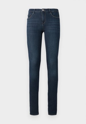Jeans slim fit bleu marine avec poches avant et arrière, fermeture à bouton et légères nuances d'usure sur les cuisses.