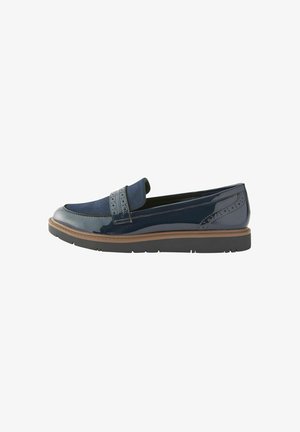 Mocassini in pelle verniciata blu navy con una fascia in tessuto, perforazioni decorative e una suola marrone a contrasto. Tacco piatto, design slip-on.
