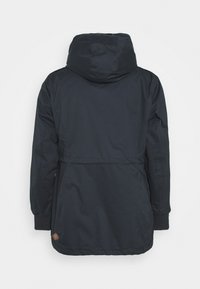 Sort hættejakke med snoretræk i taljen, elastiske manchetter og et stoflogo mærke på den nederste side. Glat tekstur og vandafvisende materiale.