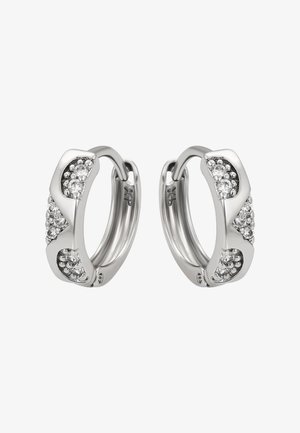 Un paio di orecchini a cerchio in argento con design a zigzag e piccole cristalli trasparenti incastonati su uno sfondo bianco.