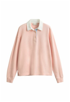 Chemise de rugby à manches longues rose pastel avec col blanc, deux boutons et poignets côtelés, présentée sur un fond blanc.
