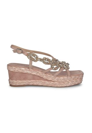 Blush pink wedge sandals with a braided jute sole. Features a strappy design and decorative chain with rhinestone accents. Buckle closure at ankle.