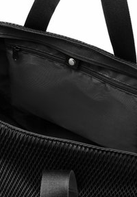 Schwarze Tragetasche mit einem Mesh-Außenmaterial, einer Reißverschlusstasche und einem glatten Innenfutter. Robustes Material und doppeltes Griffdesign.