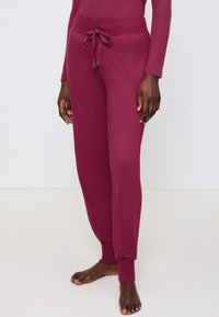 Bordeaux joggers met een zachte textuur, voorzien van een elastische tailleband en aantrekkoord. Boorden bij de enkels voor een snug fit.