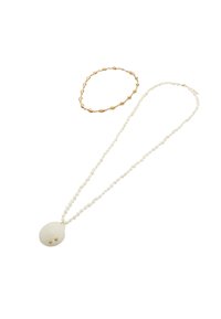 Bransoletka w kolorze złota oraz naszyjnik z białych koralików z owalnym wisiorkiem ozdobionym dwoma złotymi akcentami. Naszyjnik ma teksturowane wykończenie.