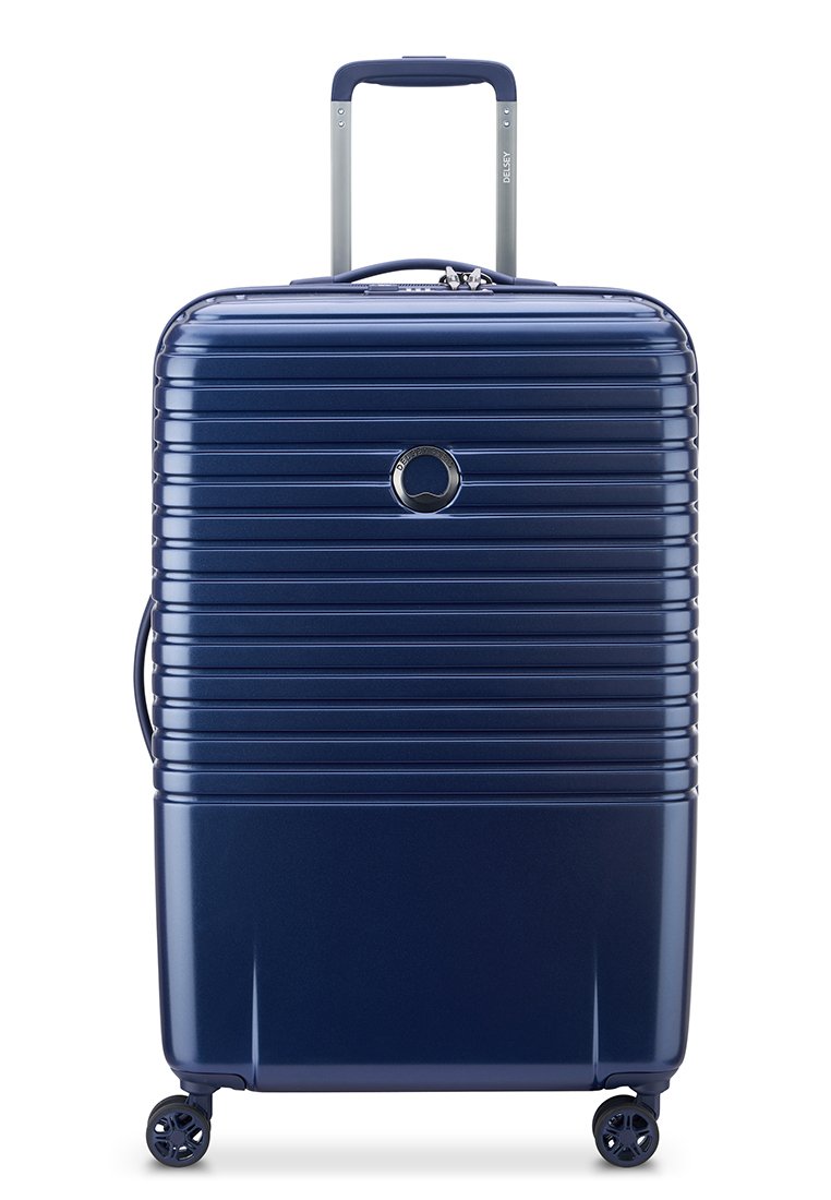 Maleta rígida navy con estrías horizontales, asa telescópica y cuatro ruedas giratorias. Presenta un logo circular en la parte frontal.