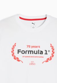 Hvid bomulds t-shirt med rød krave og fed sort og rød tryk, der siger "75 år med Formula 1® af fart og adrenalin," med laurbær accenter.