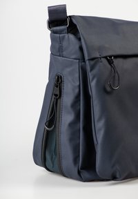 Borsa a tracolla blu navy con chiusura a patta, dotata di tasca laterale con zip e una finitura in tessuto liscio e resistente all'acqua.
