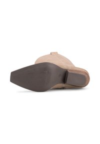 Stivale in camoscio beige con punta tondeggiante, suola in gomma marrone e tacco piatto. Presenta una linguetta laterale e dettagli cuciti.