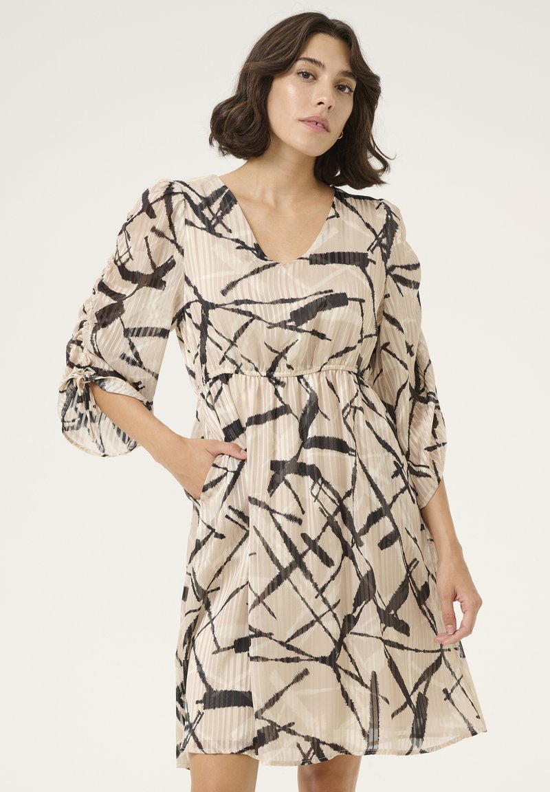 Robe avec un décolleté en V, des manches trois-quarts et un motif abstrait noir et beige. Comprend des plis doux et des poches sur les côtés.