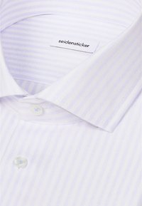 Chemise blanche à rayures verticales bleu clair, col boutonné et une étiquette portant l’inscription "seidensticker" à l’intérieur du col.