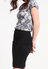 Gray patterned short-sleeve top paired with a fitted black pencil skirt, showcasing a structured silhouette and smooth textures.