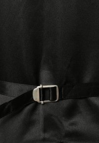 Schwarze Stoff mit glatter Textur, ausgestattet mit einem Satin-Gürtel und einer silbernen Metallschließe. Das Material ist unstrukturiert und glänzend.