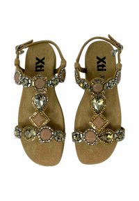 Sandali in suede beige con gemme decorative, incluse forme rotonde e a diamante, e dettagli metallici. Inclusa una cinturino regolabile per la caviglia.