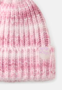 Gebreide muts in gradient tinten van roze en wit, met een geribde textuur en een klein logo-label aan de zijkant.