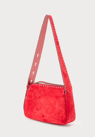 Κόκκινη σουέντ τσάντα ώμου με λευκή ραφή, φερμουάρ στην κορυφή και οπές σε σχήμα κλειδαρότρυπας στο ρυθμιζόμενο λουρί.