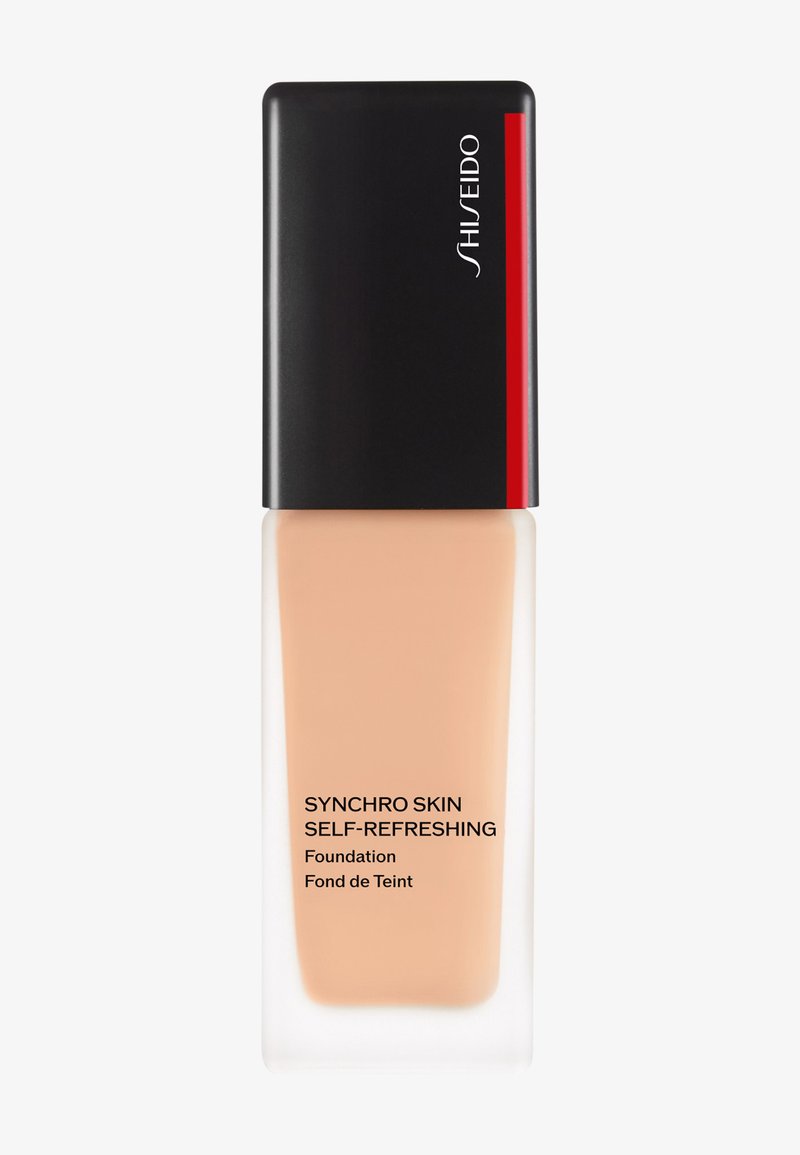 Shiseido Synchro Skin Self-Refreshing Foundation in a clear glass bottle with a black lid. Features a beige liquid and minimalist branding.