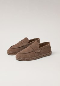 Mocassini in suede marrone con tomaia stile mocassino, suola in iuta intrecciata e dettaglio cucito sul collo. Design piatto e slip-on.