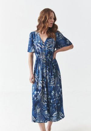 Blue floral midi dress with short sleeves, V-neck, button-down front, cinched waist, and a flowing skirt featuring a tropical leaf pattern.