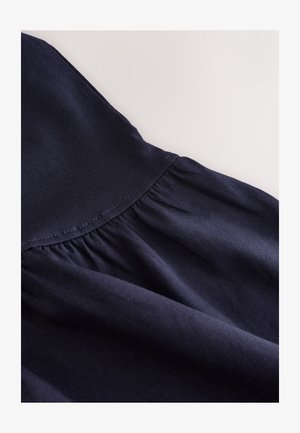 Marineblauer Stoff mit glatter Textur, der am Taillenbereich gerafft ist und einen geraden Ausschnitt aufweist. Schlichtes Design, minimalistischer Stil.