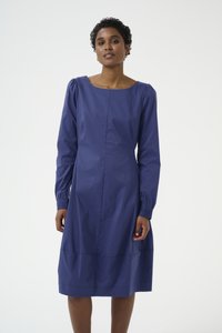 Vestido azul marino con mangas largas abullonadas, cuello barco y silueta A-line hasta la rodilla. Tejido suave con costuras estructurales sutiles.