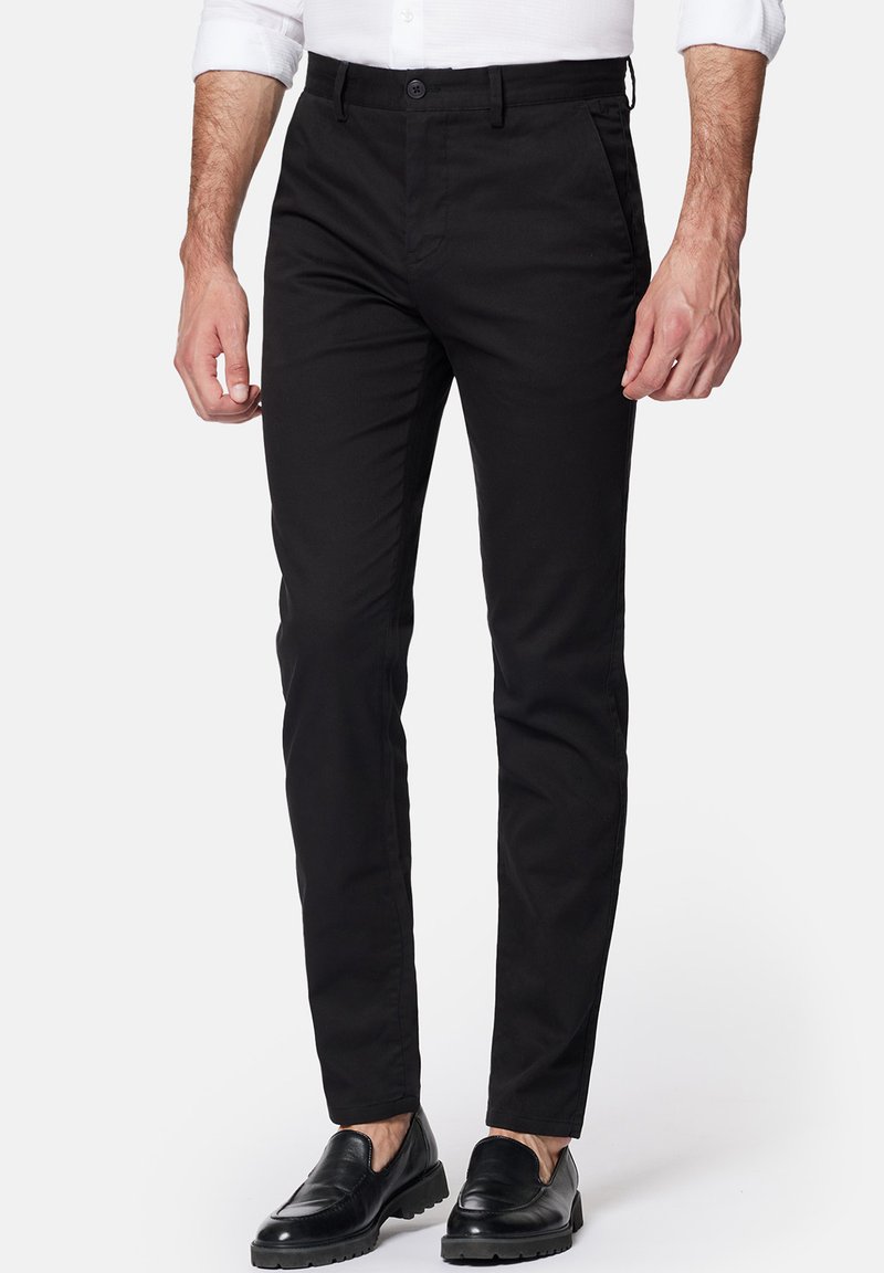 Czarne chinosy wykonane z bawełny, o dopasowanym kroju, z przednimi kieszeniami i zamkiem błyskawicznym, w połączeniu z czarnymi mokasynami, tworzą idealny zestaw.