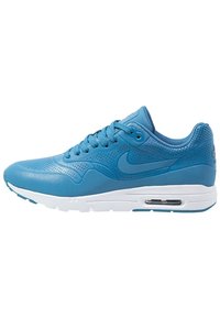 Sneaker Nike Air Max blu con tomaia in pelle perforata, suola bianca, ammortizzazione visibile e lacci blu, mostrato di lato.