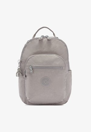 Light gray backpack made of textured fabric, featuring a rounded shape, zippered closure, front pocket, and a decorative monkey keychain.