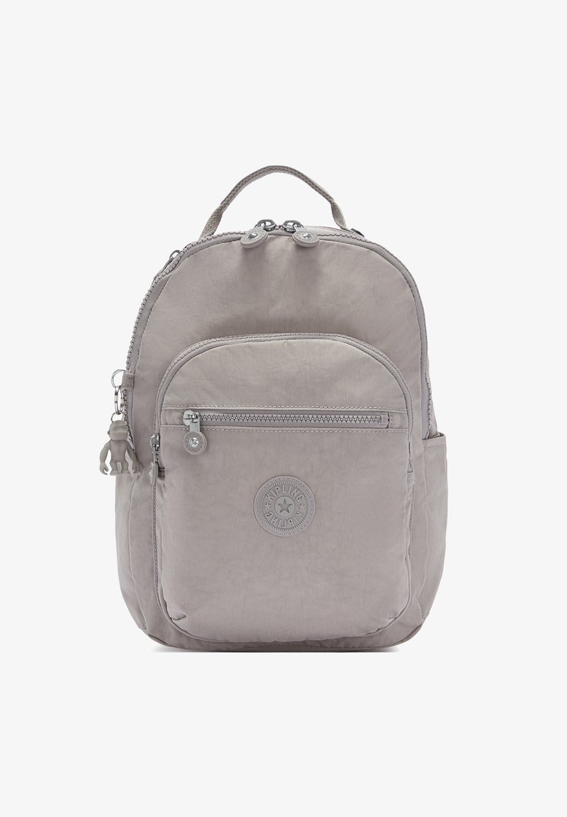 Zaino grigio chiaro realizzato in tessuto testurizzato, caratterizzato da una forma arrotondata, chiusura con zip, tasca frontale e un portachiavi a forma di scimmia decorativo.