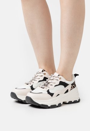 Sneakers chunky in crema, nero e stampa leopardata. Presentano pannelli in mesh, suole in gomma nere e occhielli metallici per i lacci.