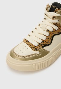 Høye sneakers i kremfarget lær med gullakenter, en panel i leopardmønstret filt og kremfargede snørebånd. Teksturelt gummisåle med riller.