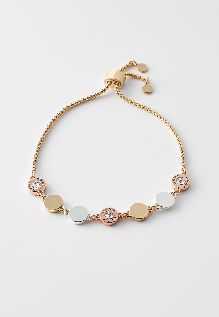 Goldene Kettenarmband mit wechselnden runden Gliedern in Roségold, Silber und Goldtönen, wobei ein Glied durch einen klaren Stein akzentuiert ist.