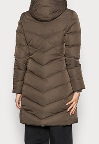 Brązowy kurtka puchowa z kapturem, z wzorem w zygzak i długimi rękawami. Gładka tekstura, średniej długości, odpowiednia na chłodne warunki.