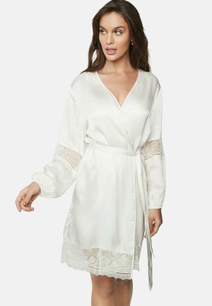 Robe en satin blanc avec des accents en dentelle sur les manches et l'ourlet. Présente un col en V, des manches longues et une ceinture à la taille pour un ajustement ajustable.