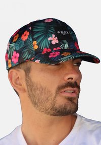 Casquette florale noire ornée de fleurs rose vif, orange et bleues, avec des feuilles vertes. Comprend un patch logo noir à l'avant.