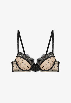 Soutien-gorge en dentelle noire avec une base en mesh nude à pois noirs, bordure festonnée et bretelles réglables. Chaque coque est ornée d'une finition décorative.