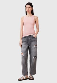 Top senza maniche rosa chiaro, jeans strappati larghi grigi scuri e sandali argentati con cinturini. Design casual con un top aderente e pantaloni a gamba larga.