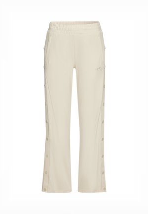 Light beige lounge pants with an elastic waistband, side pockets, and button details along the outer seams. Fabric has a soft texture.