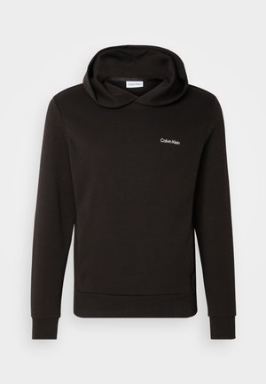 Sweatshirt de algodão preto com gola alta, mangas compridas e punhos em malha. Apresenta um pequeno logo branco da Calvin Klein no peito.