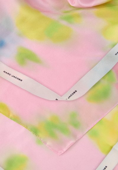 Tissu rose pastel transparent avec motif tie-dye vert et jaune, bordure blanche portant la marque "MARC JACOBS" en noir sur le bord.