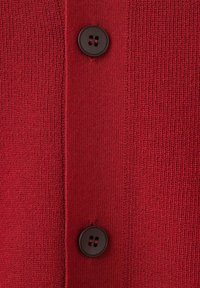 Cardigan rosso in maglia con due bottoni neri, superficie strutturata e abbottonatura centrale. Tessuto liscio e strutturato.