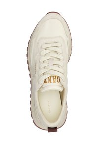 Beige Sneaker mit weißen Schnürsenkeln, strukturiertem Profil und "GANT"-Logo auf der Zunge und der Innensohle, von oben auf weißem Hintergrund betrachtet.