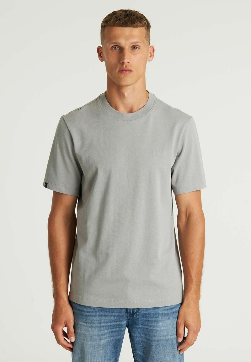 Svijetlosivi kratki rukavi majica izrađena od mekog materijala, s okruglim izrezom i malim izvezenim logotipom na prsima.