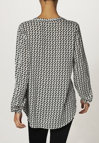 Černá a bílá košile na knoflíky s dlouhým rukávem a vzorem houndstooth, uvolněný střih, zaoblený lem a detailemi na manžetách.
