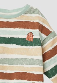 Camicetta a maniche lunghe a righe in morbido cotone, nei toni terra di verde, marrone e beige, con un piccolo dettaglio grafico di una casa.