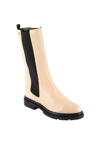 Botín de cuero beige con paneles laterales negros, punta redondeada y suela negra gruesa. Cuenta con una pestaña trasera para facilitar su puesta.